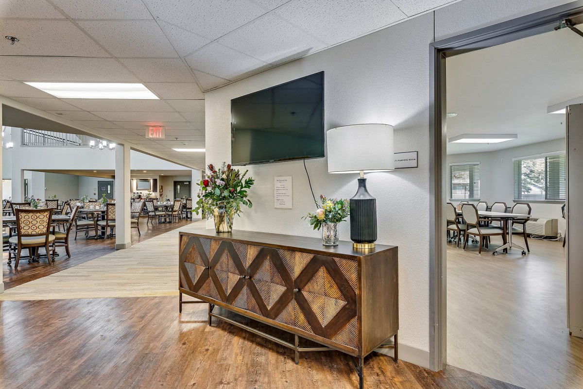 A modern interior space with a decorative console table, television, and lamp.