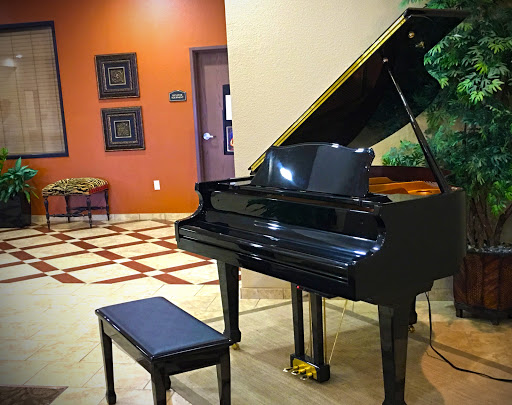A grand black piano positioned elegantly in a stylish lobby setting.