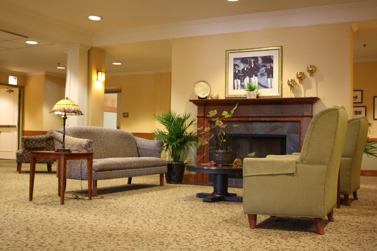 A cozy living room with a sofa, fireplace, and warm lighting.