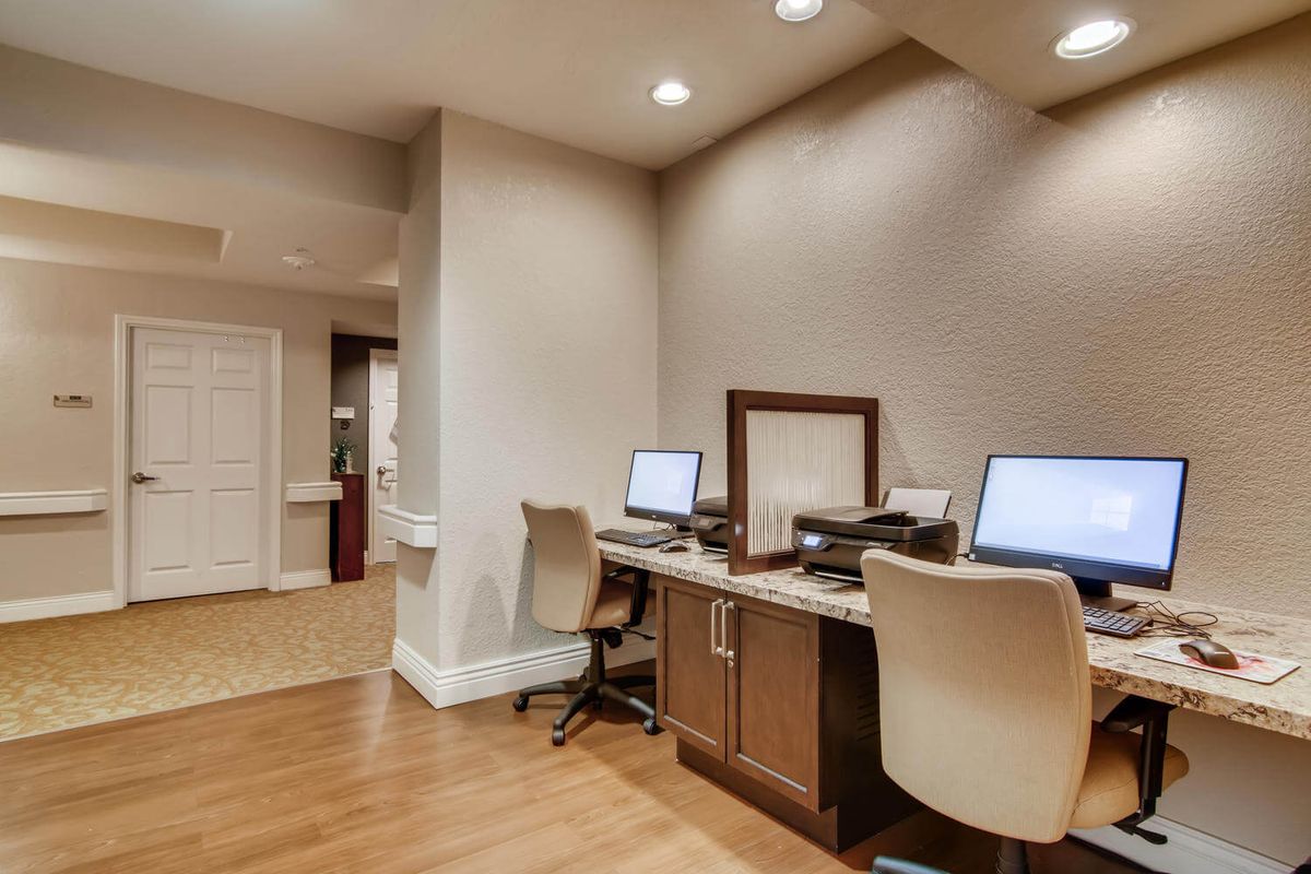 A modern office workspace featuring computers and chairs.