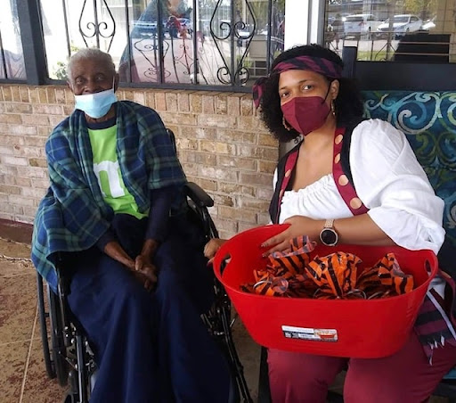 A caregiver and an elderly woman enjoying a moment outdoors, with the caregiver holding a basket filled with items.