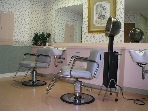 A view of a hair salon featuring barber chairs and hairstyling equipment.