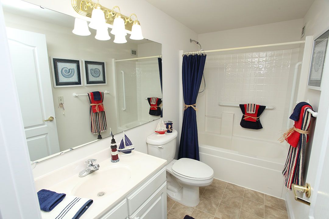 A nautical-themed bathroom with a blue shower curtain and matching towels.