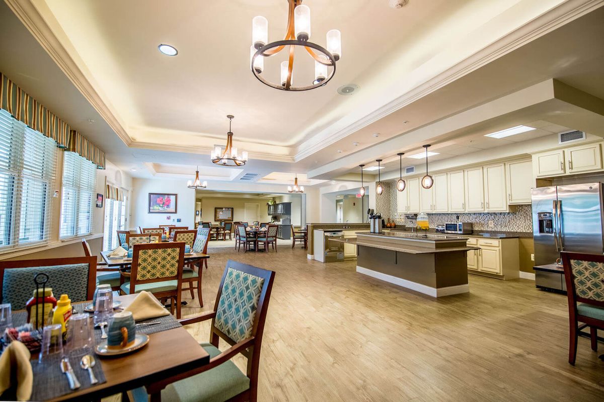 A spacious and modern dining area with elegant lighting and a central kitchen island.