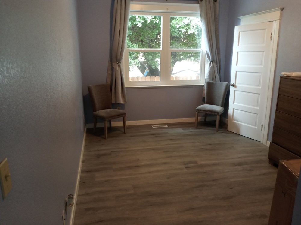 A minimalist room with two chairs by a window and simple curtains.