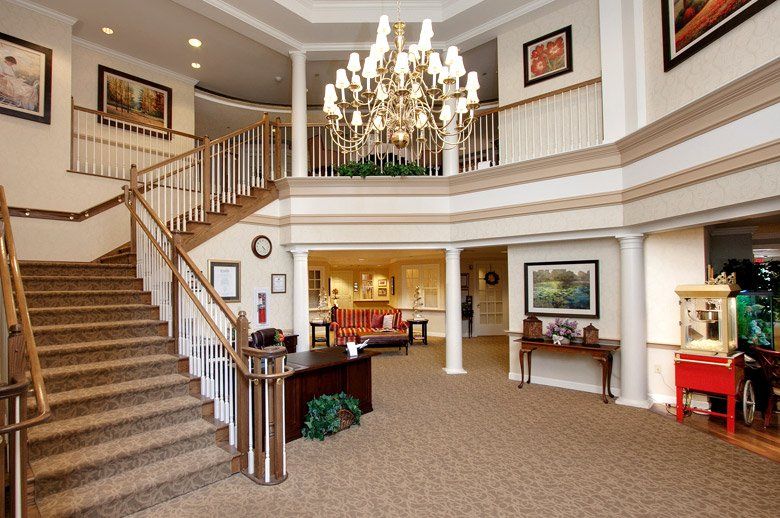 A luxurious lobby with a grand staircase and chandelier.