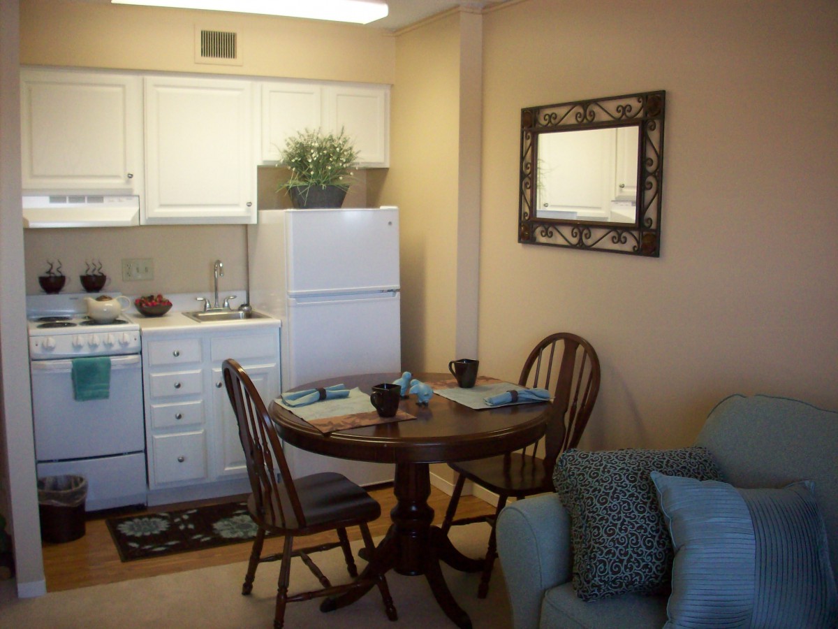 Cozy kitchen and dining area with a small table, chairs, and kitchen appliances.