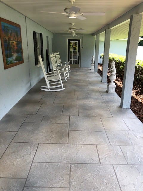 A spacious porch with rocking chairs and a garden view.