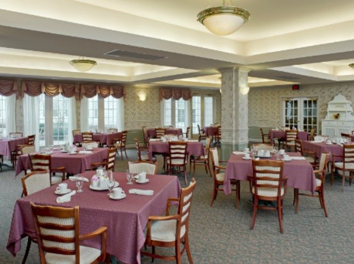 An empty dining room with tables neatly set for guests.