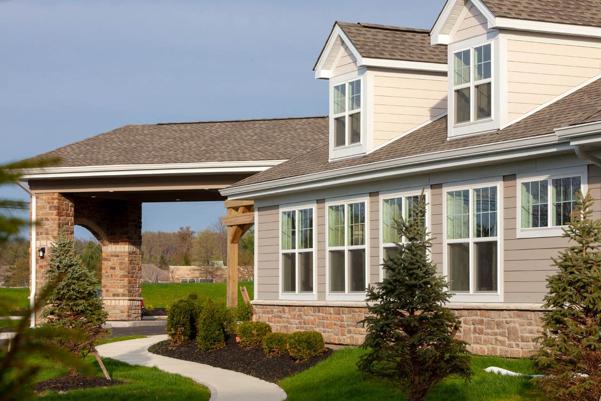 A modern residential house with large windows and well-maintained landscaping.