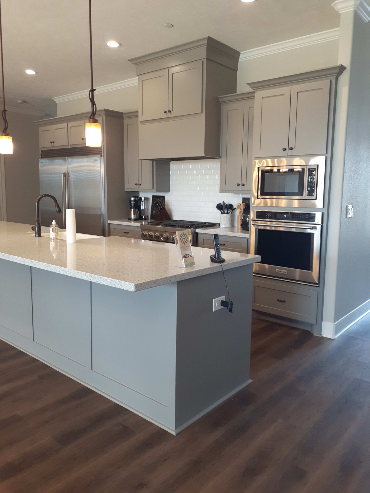 A modern kitchen with an island, stainless steel appliances, and pendant lighting.