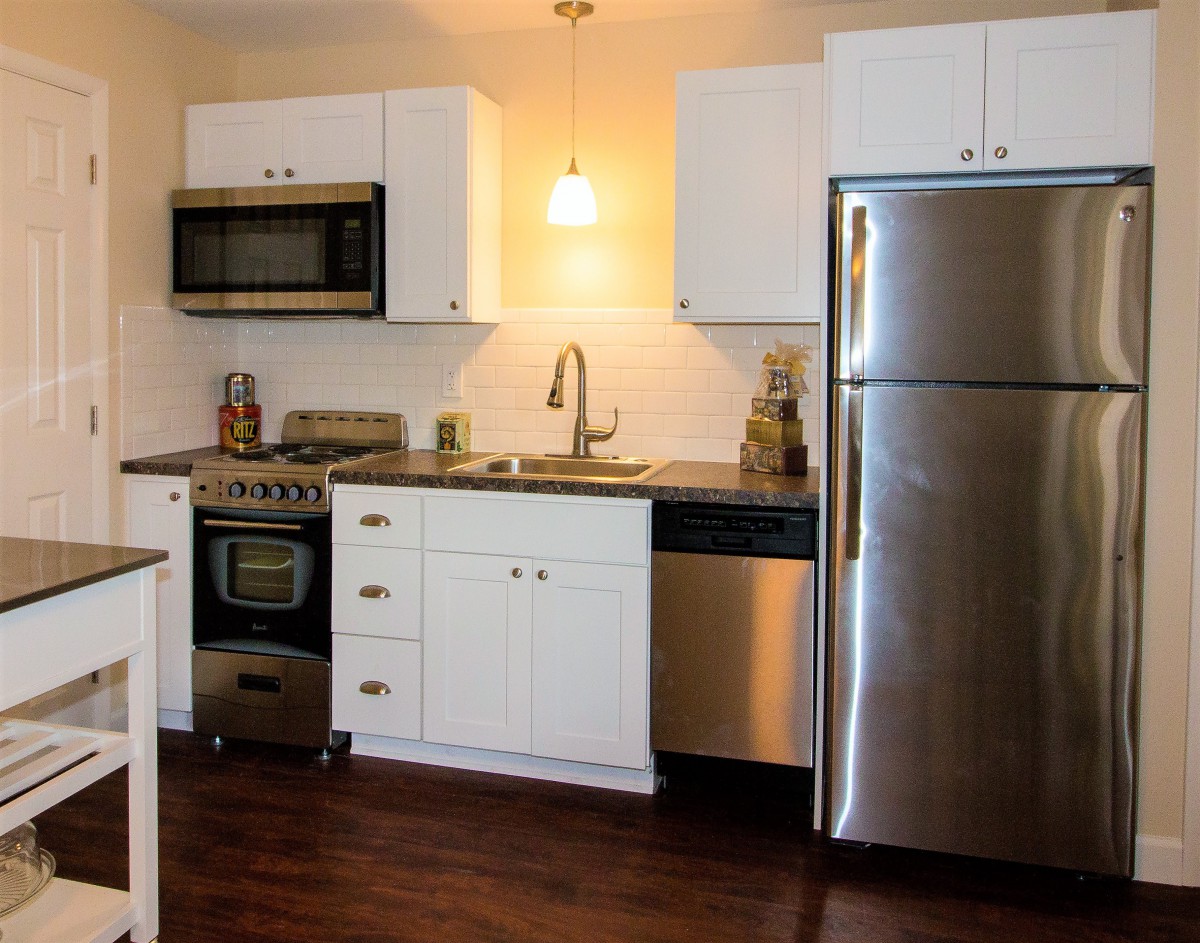 A modern kitchen with stainless steel appliances and white cabinetry.