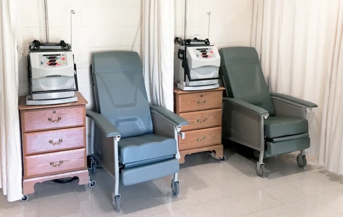 A row of medical chairs equipped with machines in a clinical setting.