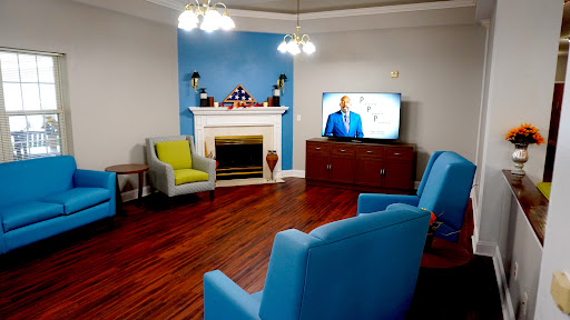 A cozy living room featuring comfortable seating, a television, and a decorative fireplace.