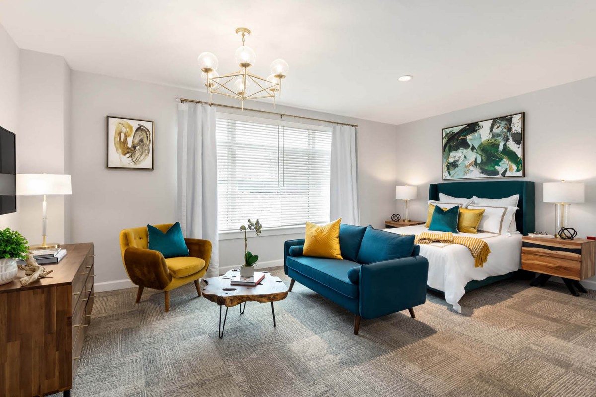 A stylish, modern living space featuring a mix of bedroom and living room elements with vibrant furniture and elegant decor.