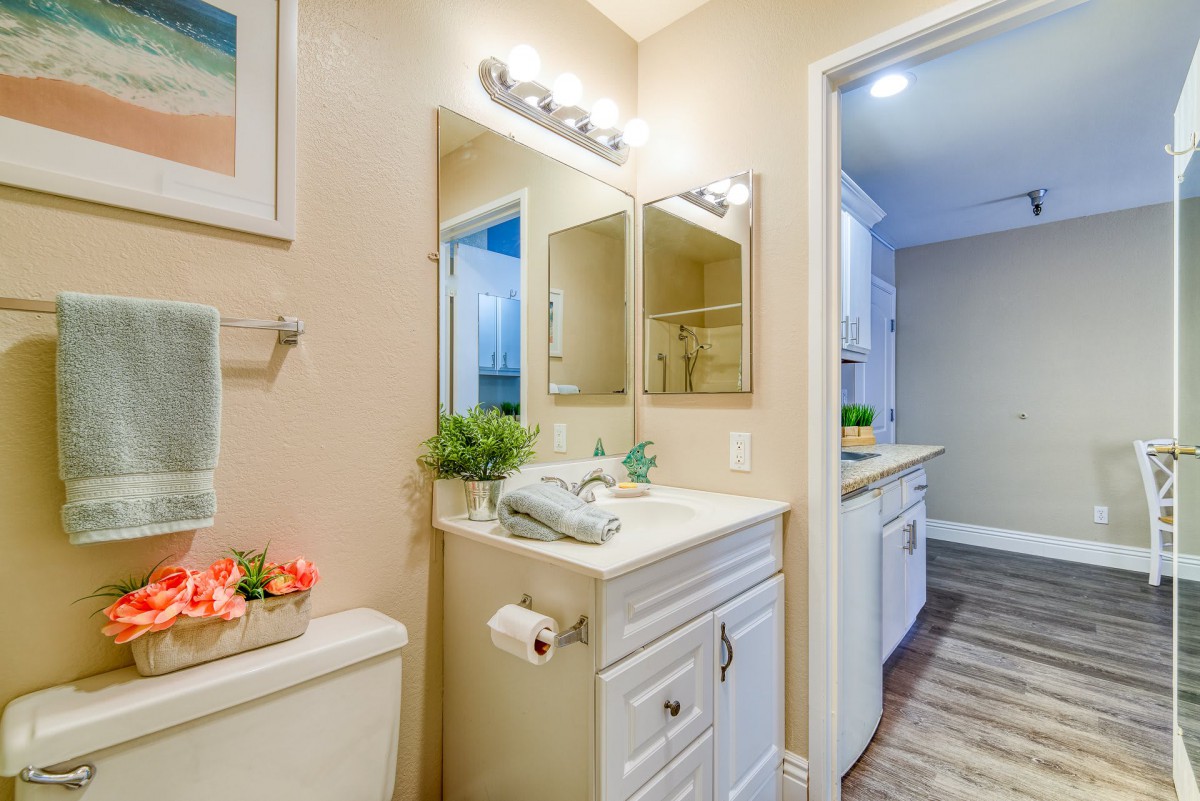 A well-lit bathroom with a vanity, mirror, and decorative accents.