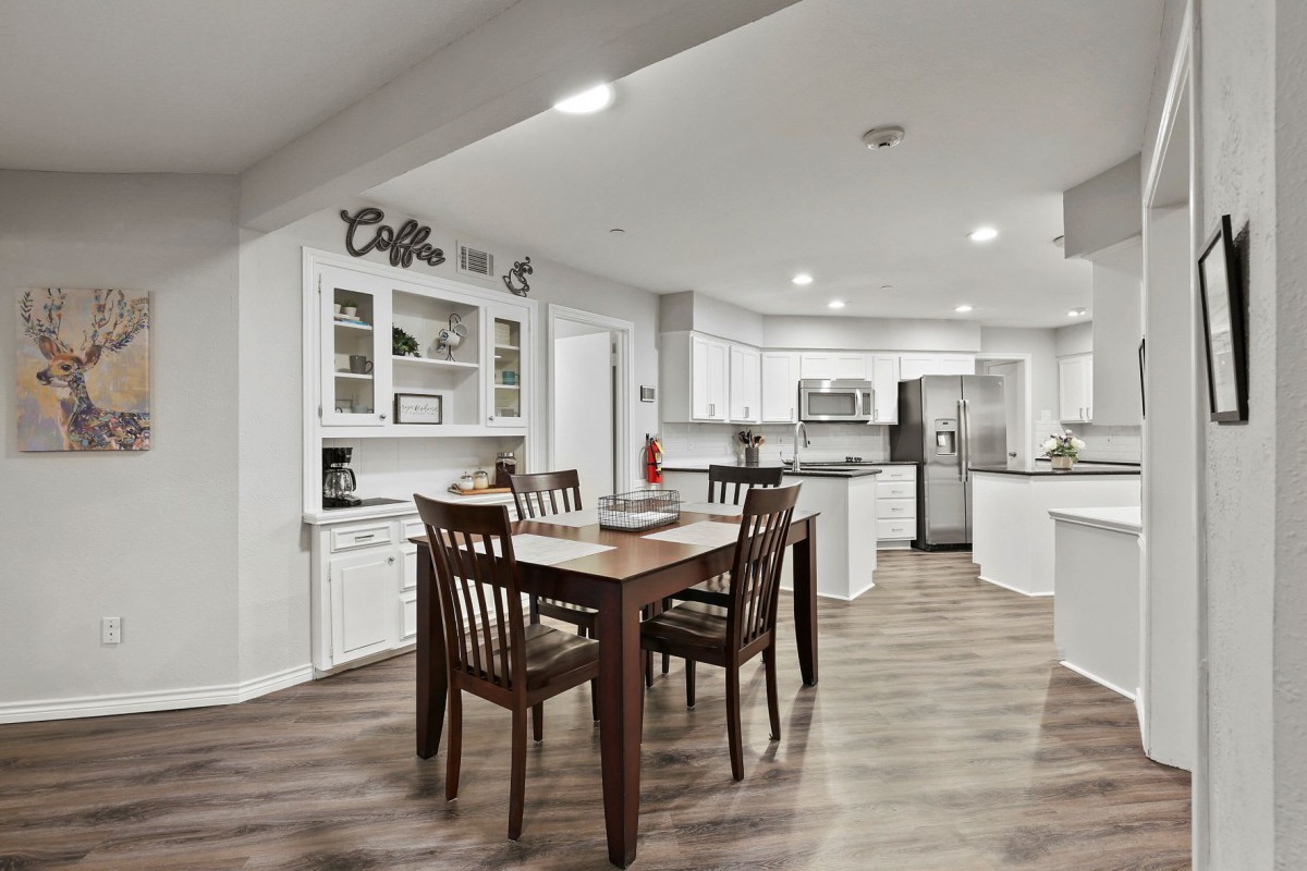 A modern open-plan kitchen and dining area with wooden flooring and stylish furniture.