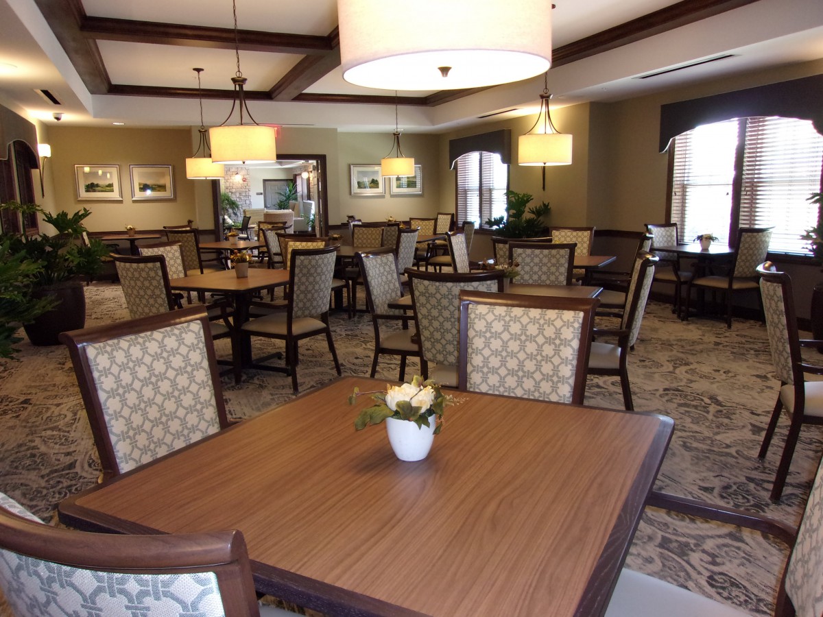 A cozy dining room with wooden tables and elegant lighting.