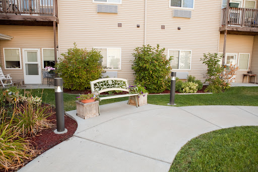 A serene outdoor area featuring a welcoming bench surrounded by lush greenery and a well-maintained pathway.