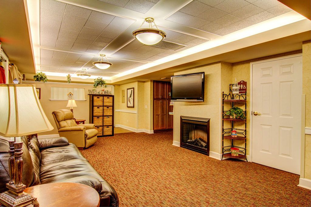A cozy living room with a sofa, television, and fireplace.