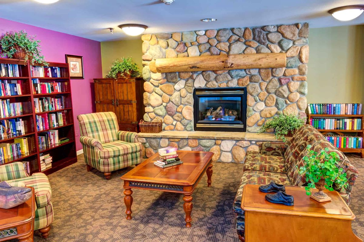 A cozy living room with a stone fireplace, comfortable seating, and a wooden coffee table.