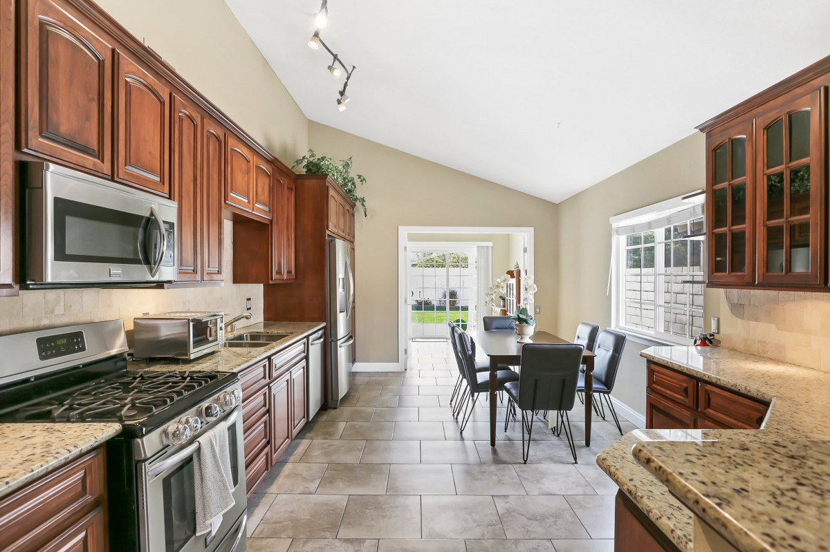 A modern kitchen with stainless steel appliances and an adjacent dining area.