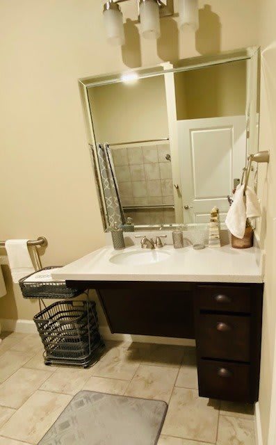 A tidy bathroom with a modern sink, large mirror, and neatly arranged towels.