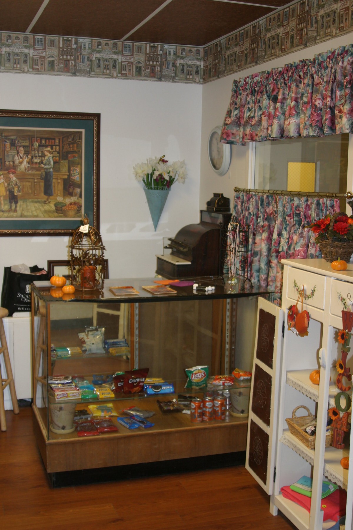 A cozy antique shop with a display case, vintage items, and decorative elements.