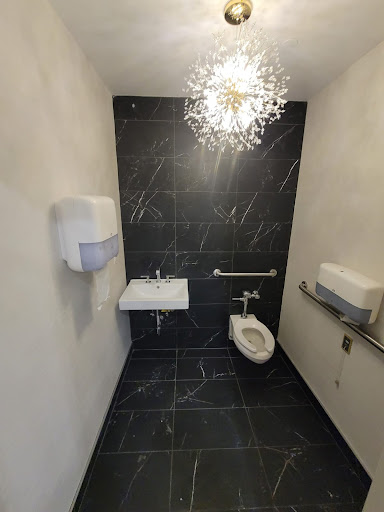 A modern bathroom featuring sleek black tiles and elegant lighting.