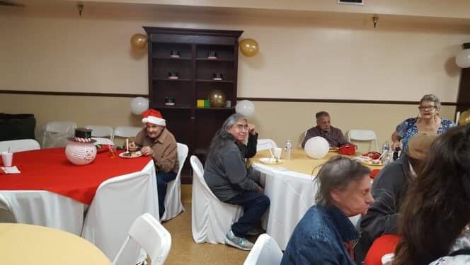 A group of people sitting at decorated tables during a festive gathering.