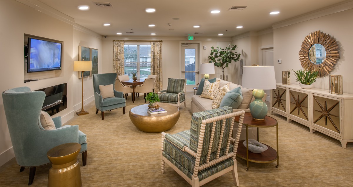 A stylish and comfortable living room with modern furniture, featuring a central coffee table, armchairs, and elegant decor.