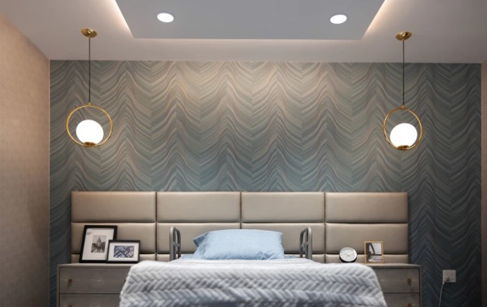 A contemporary bedroom featuring elegant wallpaper, pendant lighting, and a plush headboard.