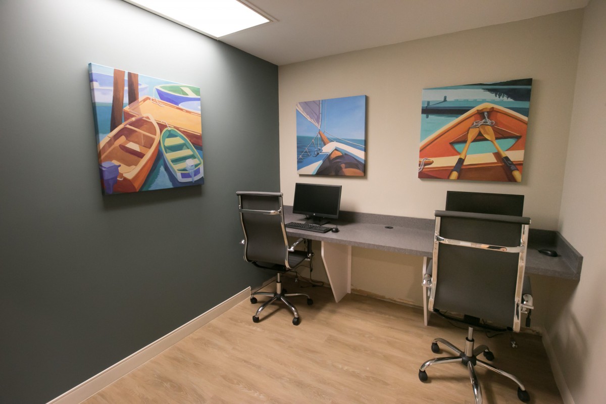 A modern office space with computers and vibrant paintings on the walls.