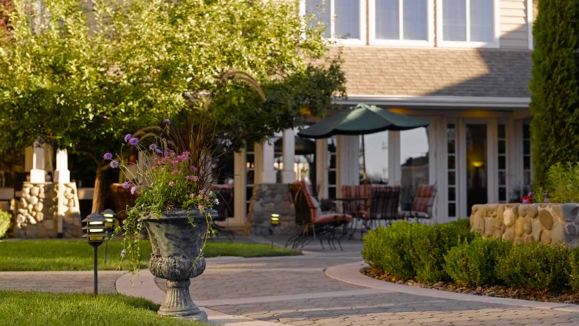 A cozy patio with outdoor seating and lush garden landscaping.