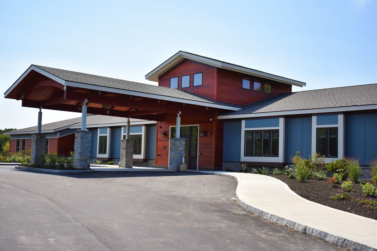 A modern building with a welcoming entrance and a curved driveway.