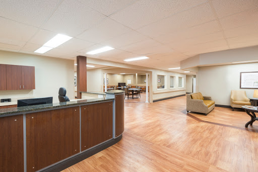 A modern office reception area featuring a counter, seating, and a spacious layout.