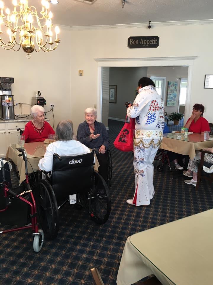 A performer in costume interacts with elderly residents at a nursing home.