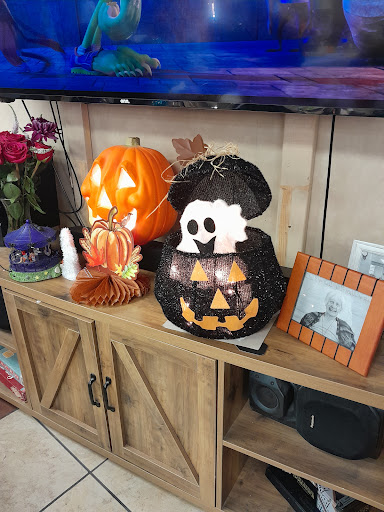 A cozy Halloween display featuring carved pumpkins, a ghost decoration, and autumn-themed accents.