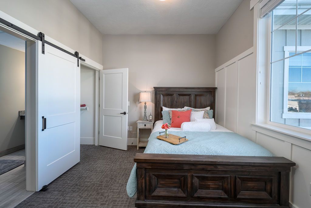 A cozy and modern bedroom with a large bed, bedside lamp, and stylish decor.