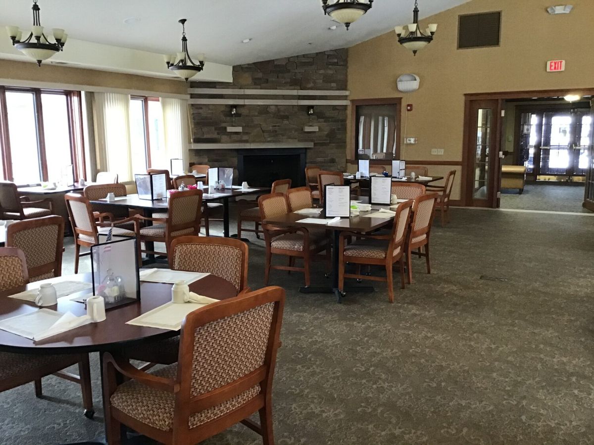 An empty restaurant dining area with neatly arranged tables and chairs.