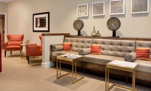 A modern living room with a stylish sofa, decorative pillows, and minimalist coffee tables.