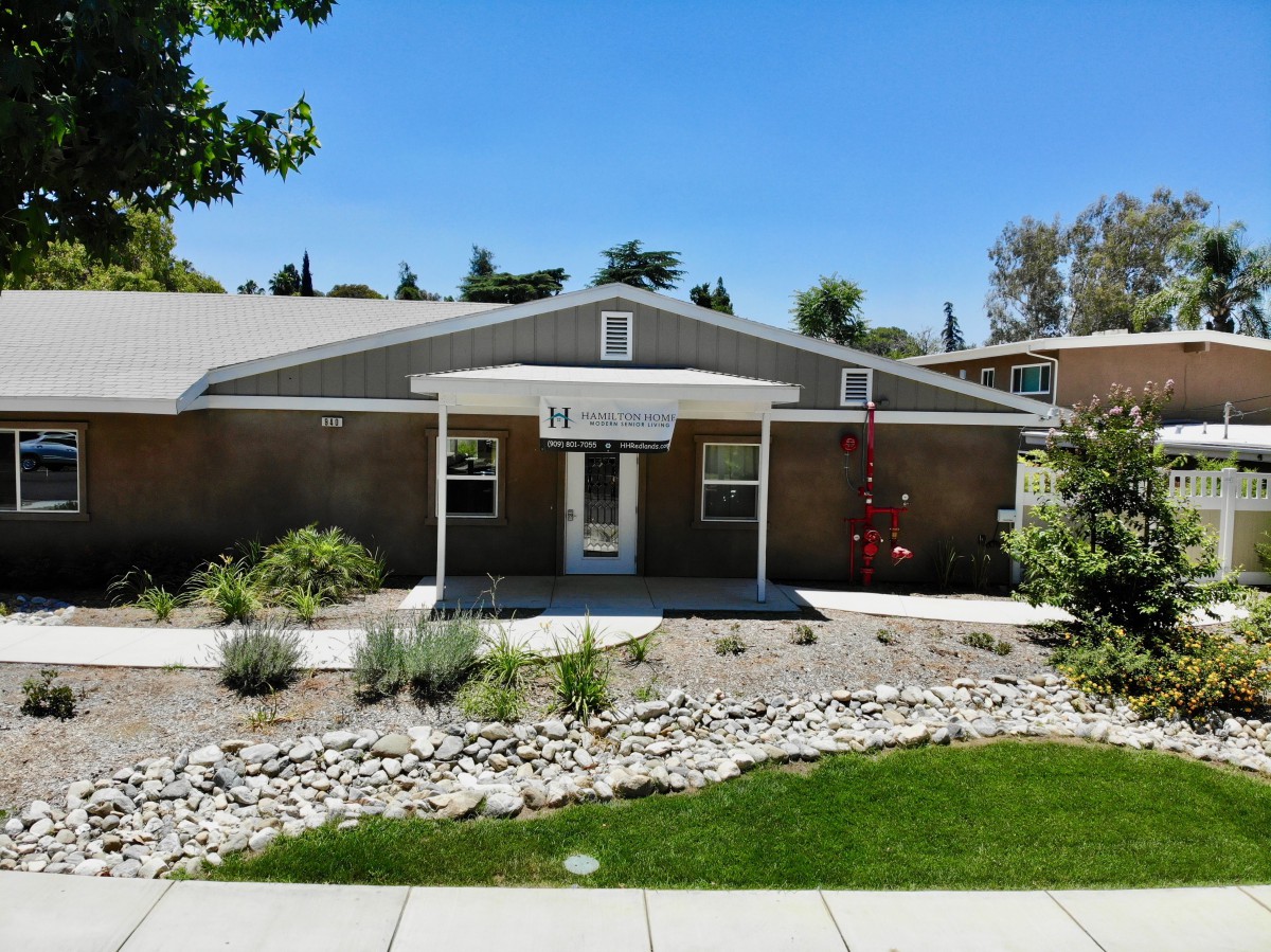 A single-story building with a well-maintained front yard and clear blue sky.