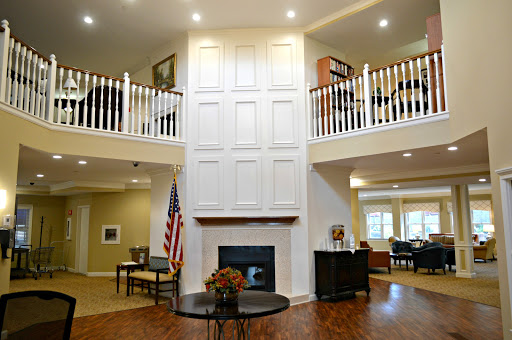 A spacious and welcoming lobby featuring a double-height ceiling, fireplace, and comfortable seating.