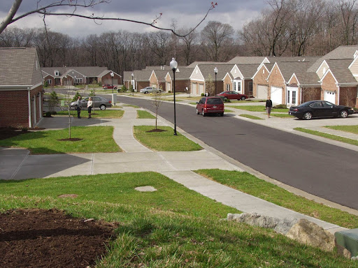 A quiet suburban neighborhood featuring lined houses, well-maintained sidewalks, and a winding road.