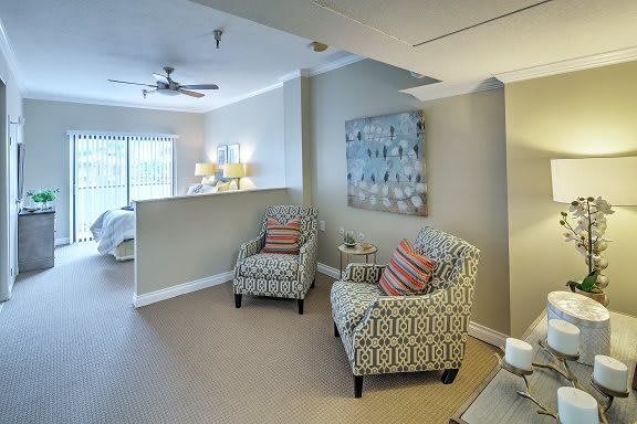 A cozy living room setup featuring patterned chairs, decorative pillows, and wall art.