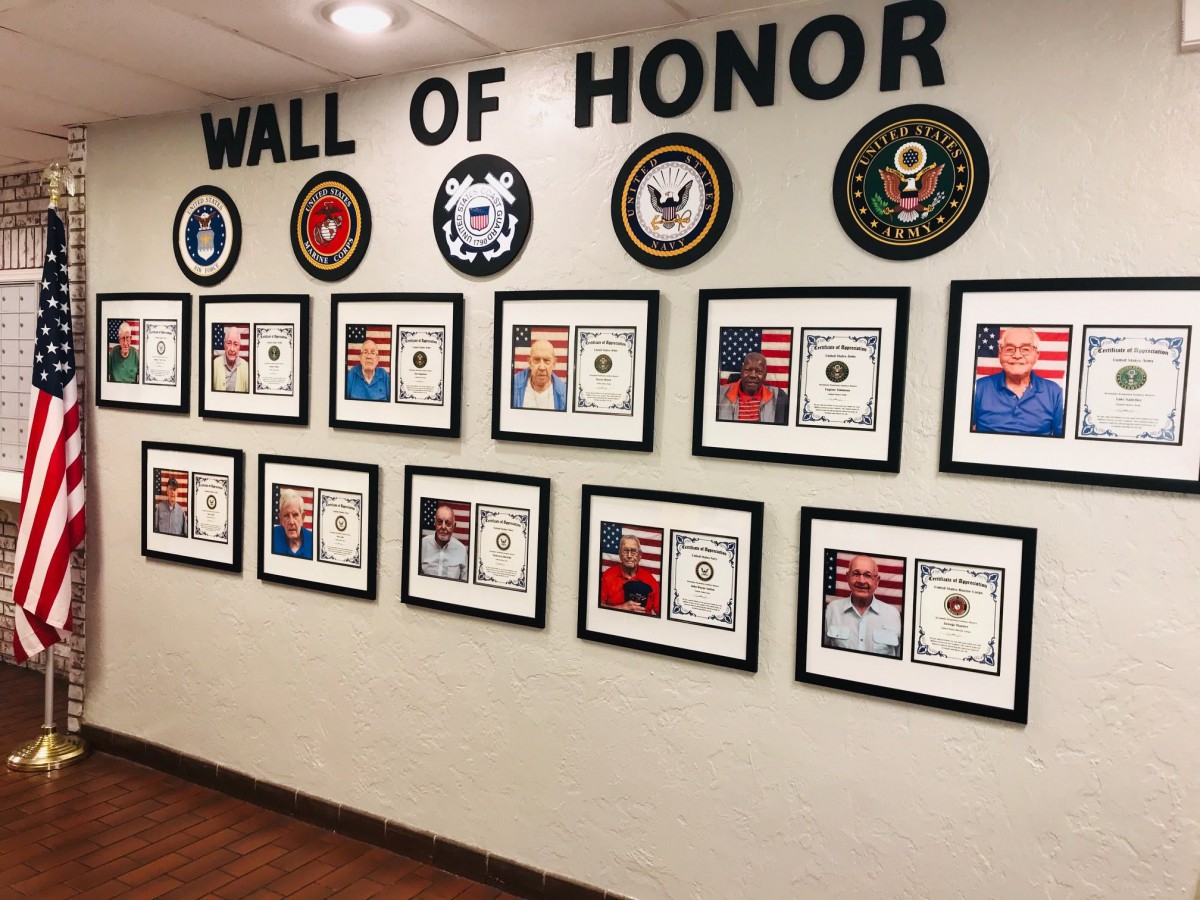 A Wall of Honor showcasing framed military awards and plaques.
