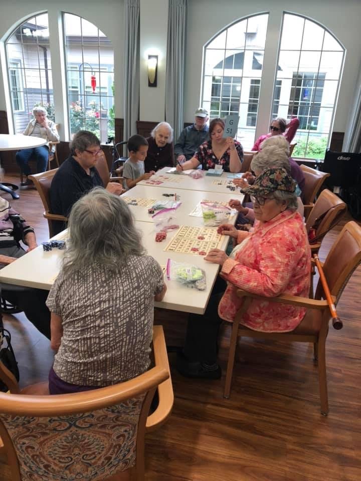 A group of elderly individuals engaging in an art and crafts activity indoors.