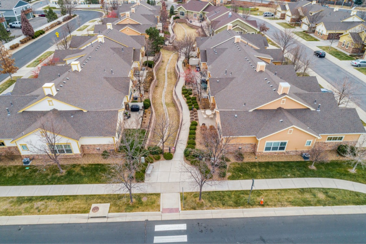 Aerial view of a residential neighborhood with neatly arranged houses and landscaped pathways.