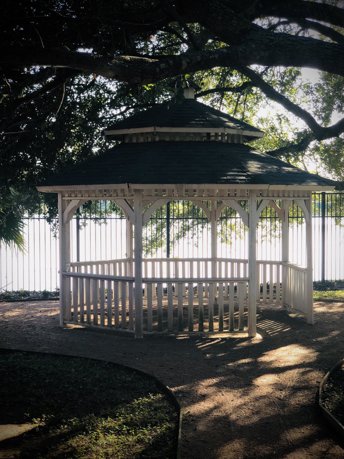 A charming gazebo surrounded by lush trees, providing a peaceful retreat in the park.