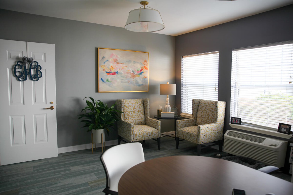 A modern living room with neutral tones, featuring comfortable seating and artistic decor.